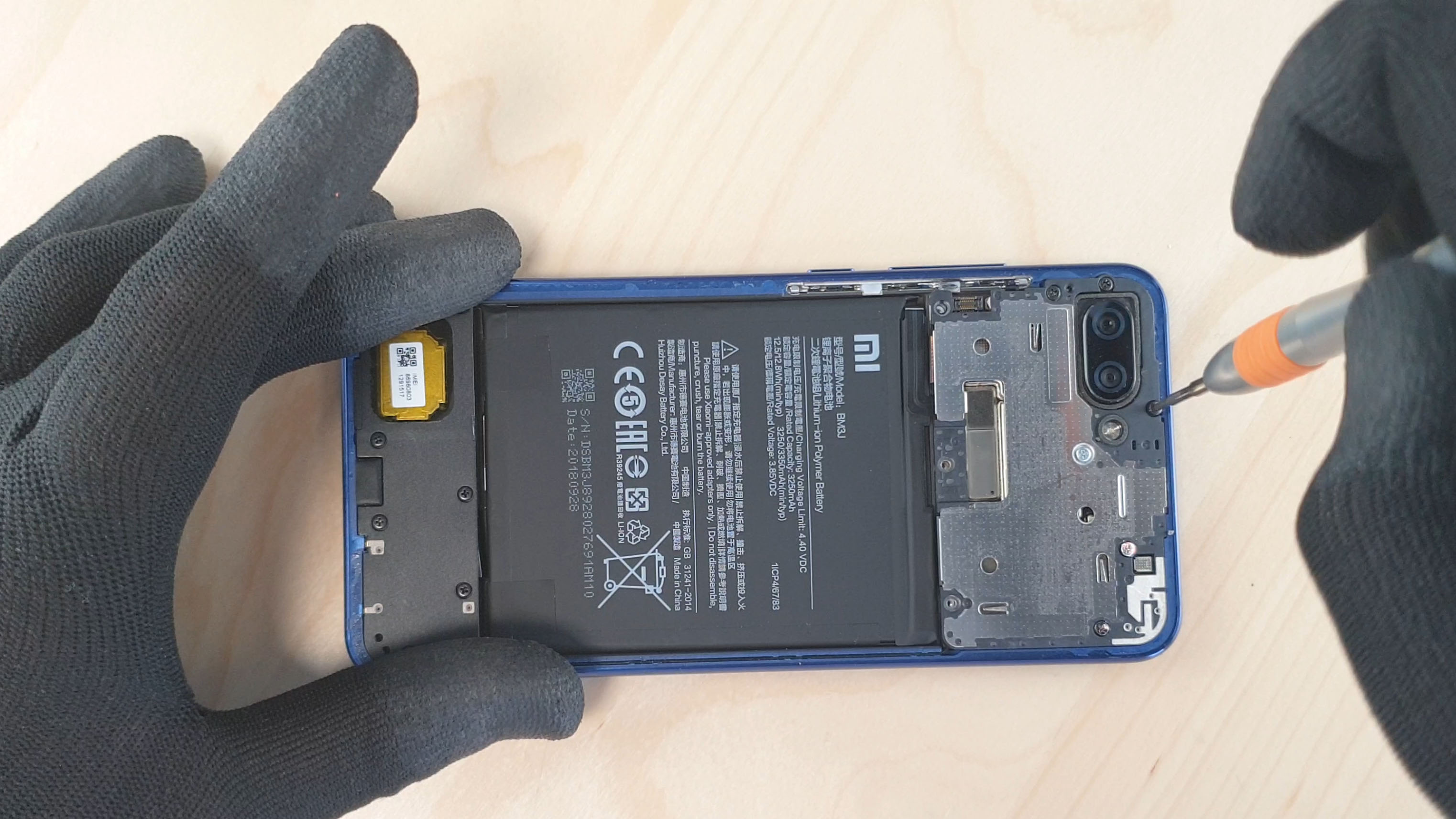 Changer la batterie du Mi8 Lite en dévissant le cache de protection de la carte mère